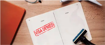 Pasaporte con sello de visa denegada sobre escritorio